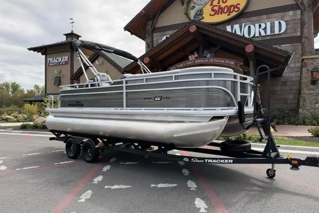 The Image of 2027 Sun Tracker SportFish 20 DLX pontoon boat on trailer outside Bass Pro Shops. - 0