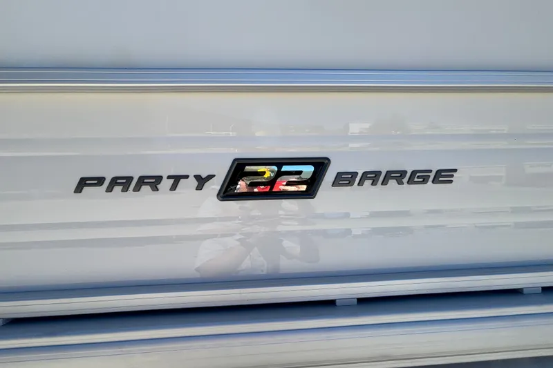 Slide: The Image of 2027 Sun Tracker Party Barge 22 DLX logo on boat exterior. - 16