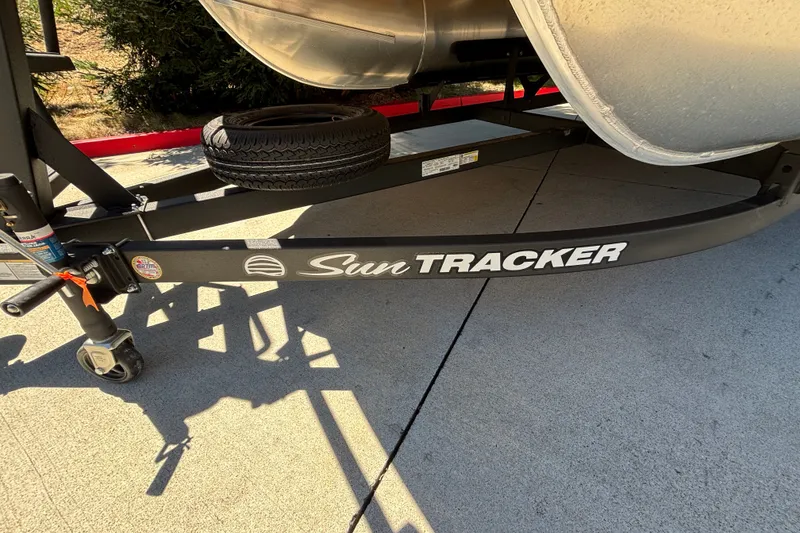Slide: The Image of 2027 Sun Tracker Party Barge 22 DLX trailer with spare tire on concrete surface. - 59