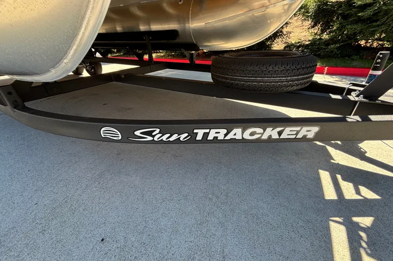 Slide: The Image of 2027 Sun Tracker Party Barge 22 DLX trailer with spare tire on concrete surface. - 55