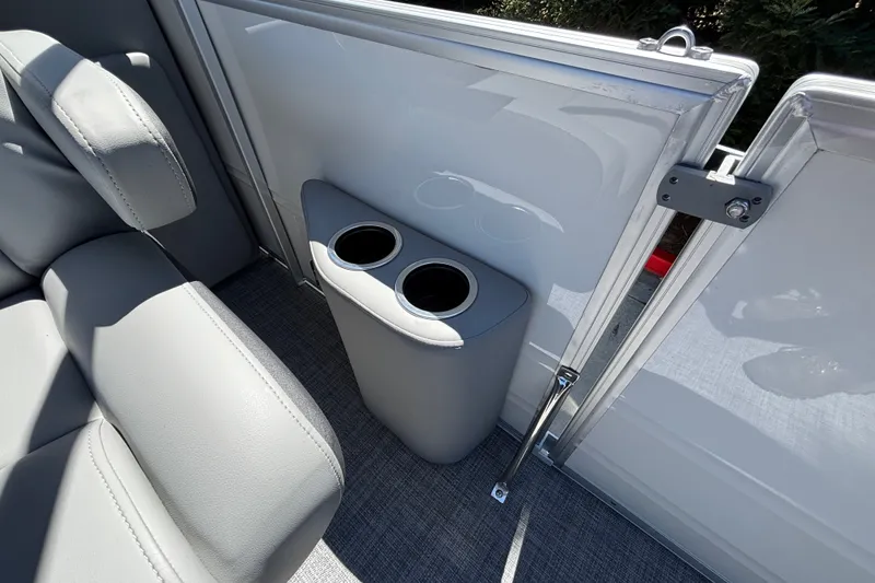 Slide: The Image of 2027 Sun Tracker Party Barge 22 DLX interior with cup holders and gray seating. - 21