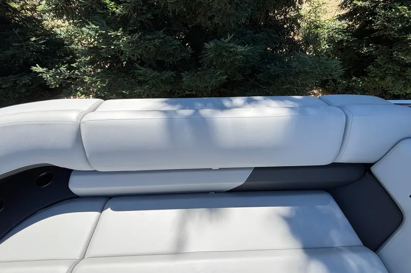 Slide: The Image of Sun Tracker Party Barge 22 DLX 2027 boat seating with lush greenery background. - 32