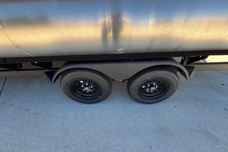 Slide: The Image of Trailer wheels of a 2027 Sun Tracker Party Barge 22 DLX on concrete surface. - 42