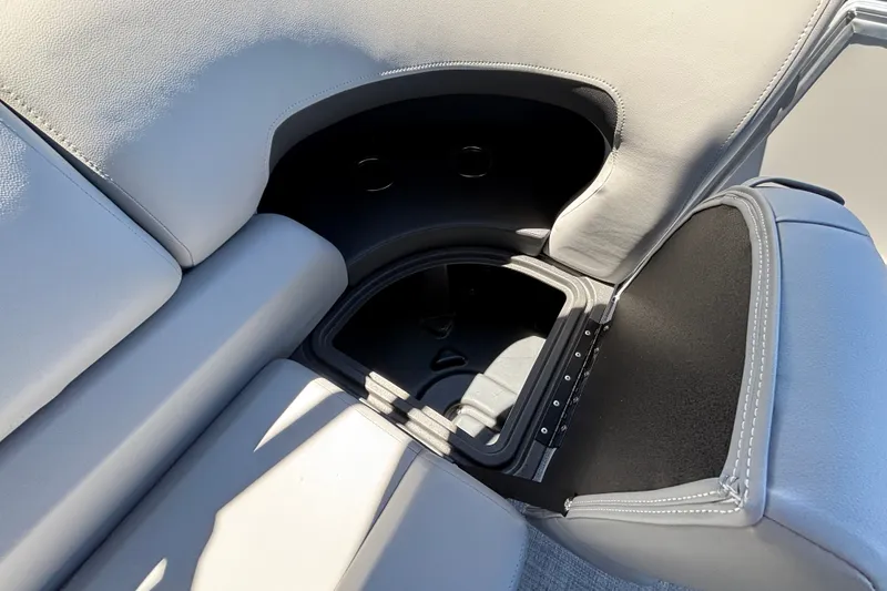 Slide: The Image of Sun Tracker Party Barge 22 DLX 2027, open storage compartment in gray seating. - 19
