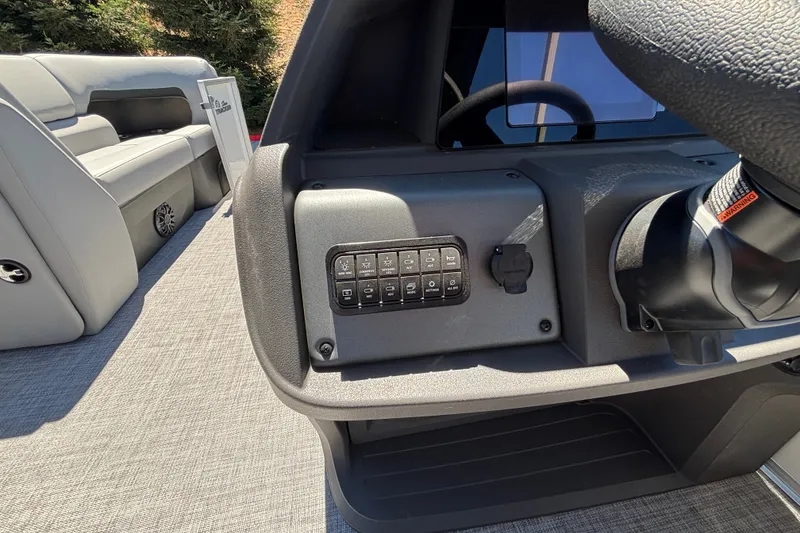Slide: The Image of 2027 Sun Tracker Party Barge 22 DLX dashboard with control panel and seating area. - 49