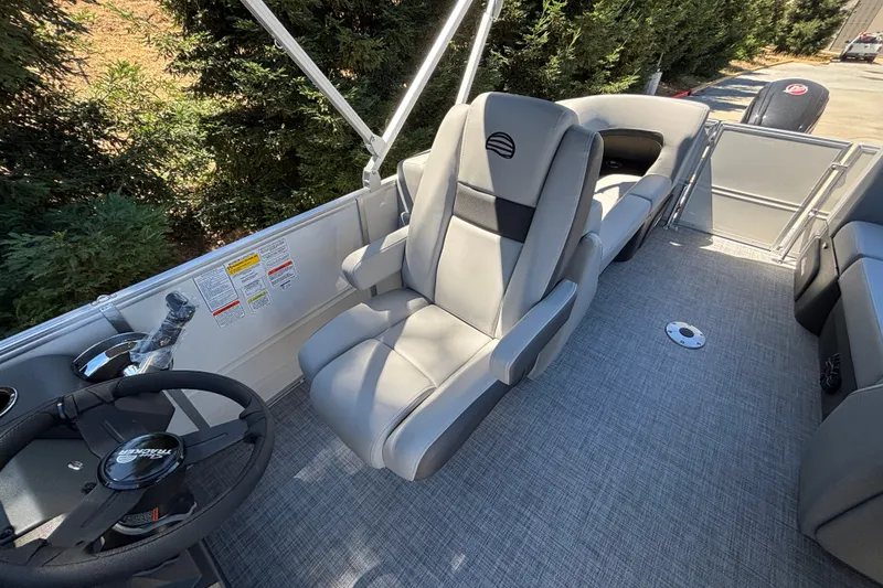 Slide: The Image of 2027 Sun Tracker Party Barge 22 DLX interior with gray seating and steering wheel. - 15