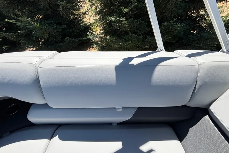 Slide: The Image of 2027 Sun Tracker Party Barge 22 DLX interior seating with lush greenery background. - 37