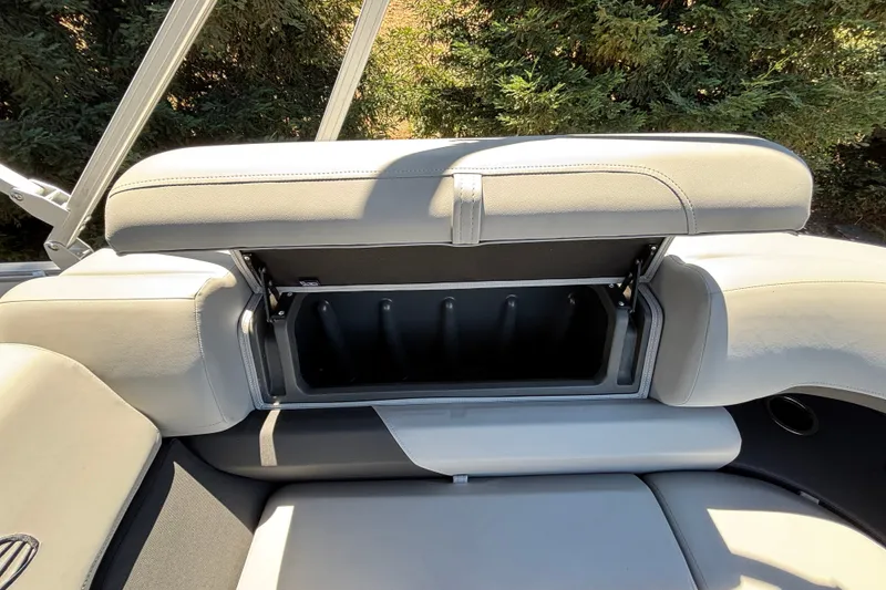 Slide: The Image of 2027 Sun Tracker Party Barge 22 DLX storage compartment with open seat cushion. - 38