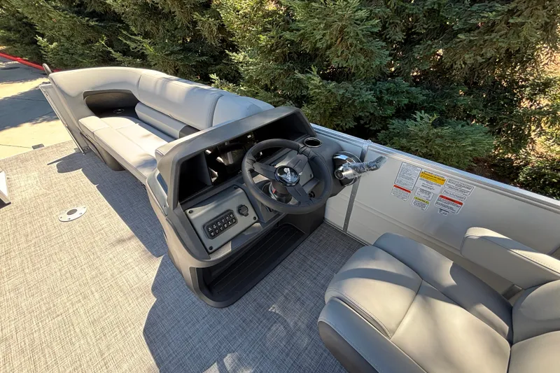 Slide: The Image of 2027 Sun Tracker Party Barge 22 DLX interior with steering console and seating. - 14