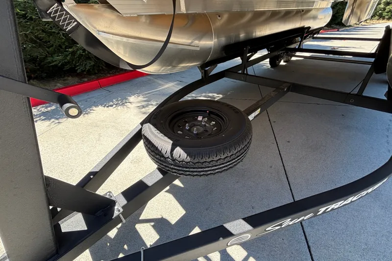 Slide: The Image of Trailer of 2027 Sun Tracker Party Barge 22 DLX with spare tire on pavement. - 58