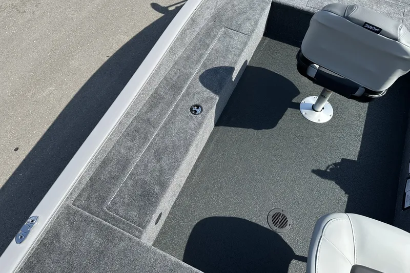 Slide: The Image of 2027 Tracker Super Guide V-16 T boat interior with gray carpet and swivel seat. - 17