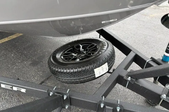 Slide: The Image of 2027 Tracker Targa V-18 WT boat trailer with spare tire on asphalt. - 15