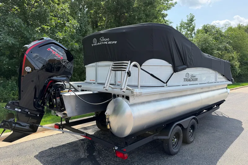 Slide: The Image of 2027 Sun Tracker Party Barge 22 DLX pontoon boat on trailer, covered and ready for transport. - 23