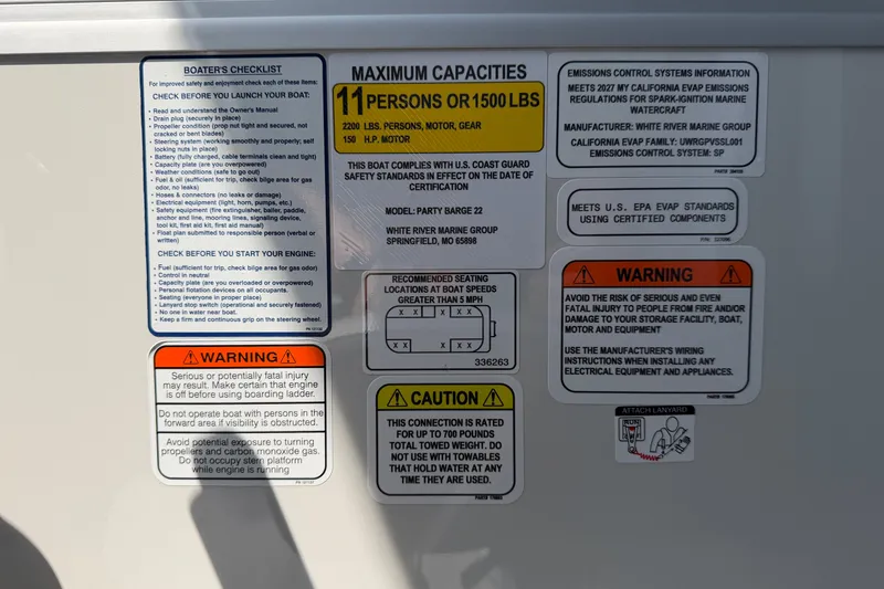 Slide: The Image of Sun Tracker Party Barge 22 DLX 2027 safety and capacity labels on boat panel. - 21