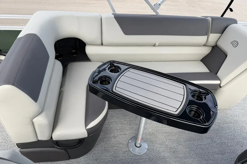 Slide: The Image of 2027 Sun Tracker Fishin' Barge 22 DLX interior with cushioned seating and table. - 22