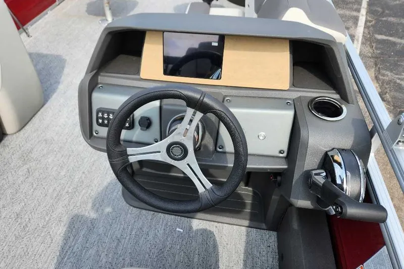 Slide: The Image of 2027 Sun Tracker Fishin' Barge 22 DLX dashboard with steering wheel and controls. - 16