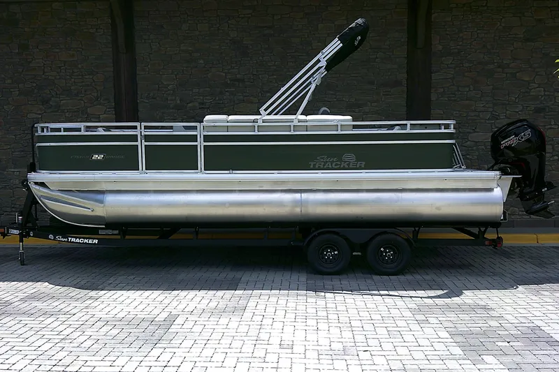 The Image of 2027 Sun Tracker Fishin' Barge 22 DLX pontoon boat on trailer, side view. - 0