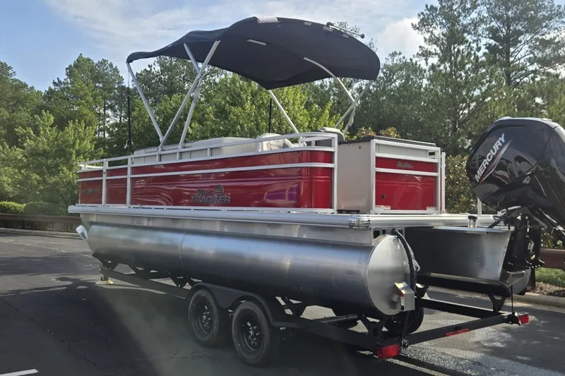 The Image of 2027 Sun Tracker Fishin' Barge 22 DLX pontoon boat with canopy and Mercury outboard motor. - 0
