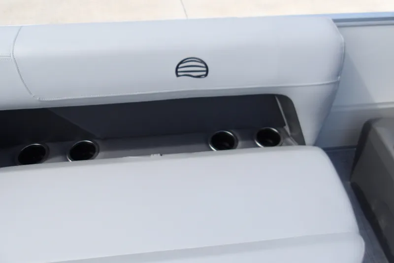 Slide: The Image of 2027 Sun Tracker Party Barge 16 DLX interior with cup holders and cushioned seating. - 18