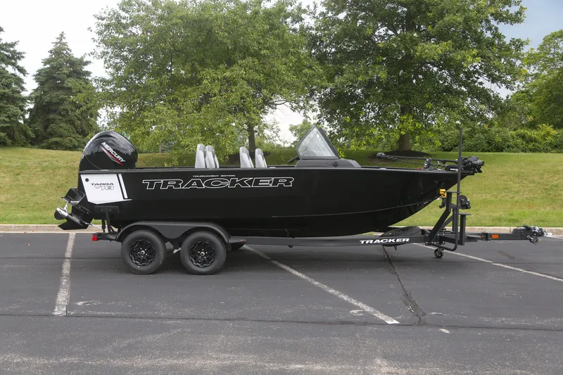 The Image of 2027 Tracker Targa V-18 WT boat on trailer in parking lot, surrounded by greenery. - 0