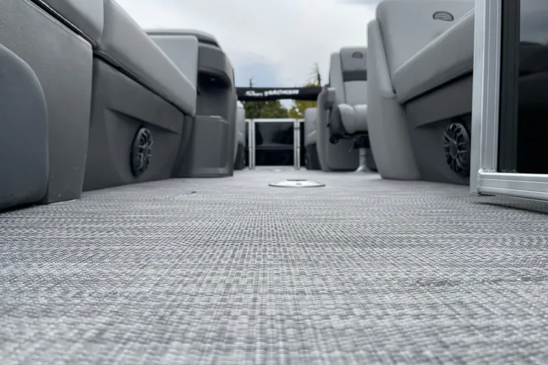 Slide: The Image of 2027 Sun Tracker Party Barge 22 DLX interior with gray seating and flooring. - 24