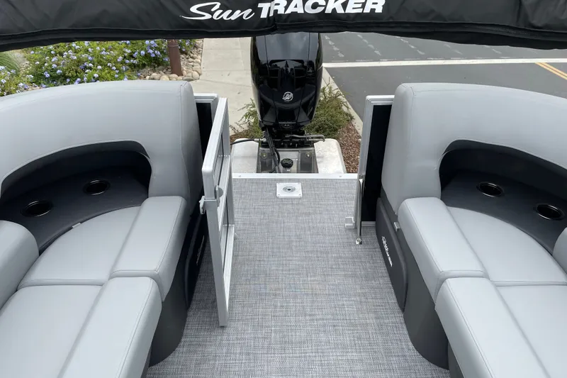 Slide: The Image of 2027 Sun Tracker Party Barge 22 DLX interior with seating and motor view. - 19