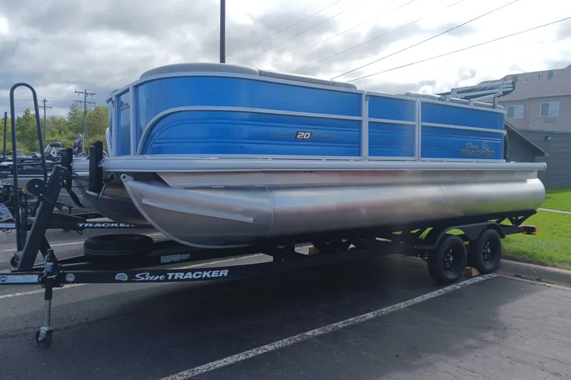The Image of 2027 Sun Tracker Party Barge 20 DLX pontoon boat on trailer, parked outdoors. - 0