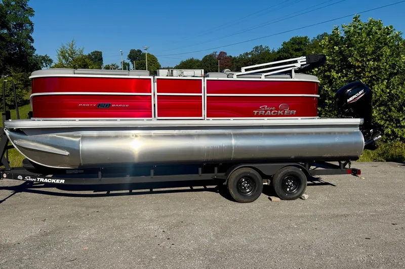 The Image of 2027 Sun Tracker Party Barge 20 DLX pontoon boat on trailer, parked outdoors. - 0