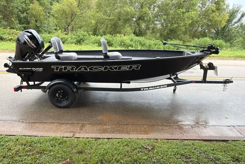 The Image of 2027 Tracker Super Guide V-16 T boat on trailer, parked on wet road. - 0