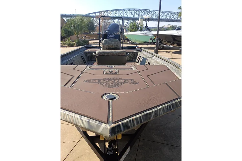 Slide: The Image of 2027 Tracker Grizzly 1860 CC boat with custom deck, displayed outdoors near a bridge. - 66