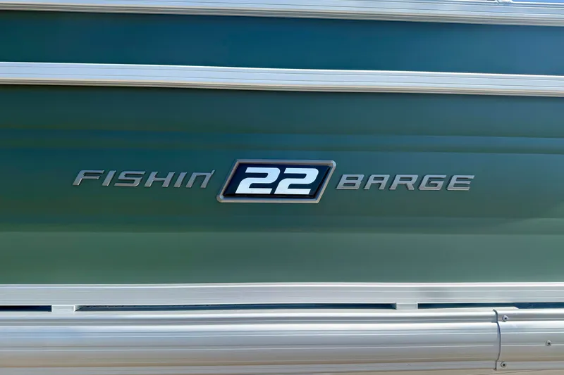 Slide: The Image of 2027 Sun Tracker Fishin' Barge 22 DLX logo on green boat exterior. - 14