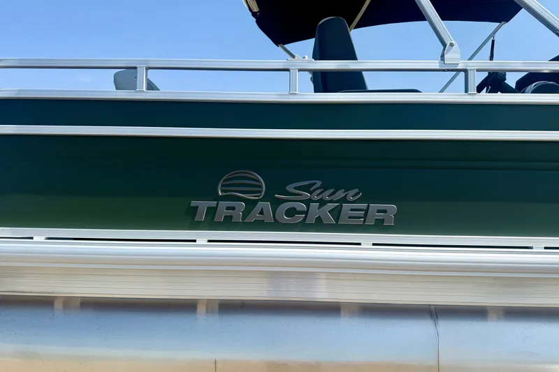 Slide: The Image of 2027 Sun Tracker Fishin' Barge 22 DLX pontoon boat with sleek design and logo. - 13