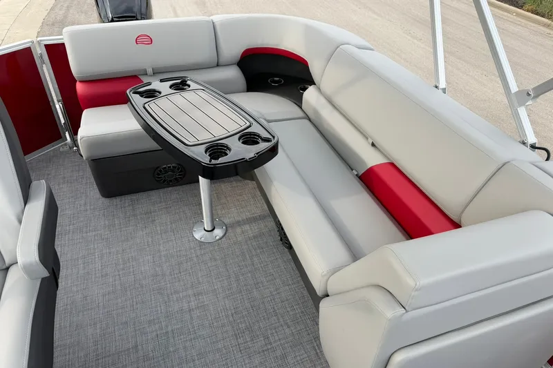 Slide: The Image of 2027 Sun Tracker Party Barge 20 DLX interior with gray and red seating, and a central table. - 17