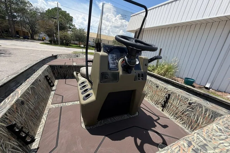 Slide: The Image of 2027 Tracker Grizzly 1860 CC boat interior with camouflage design and steering console. - 57