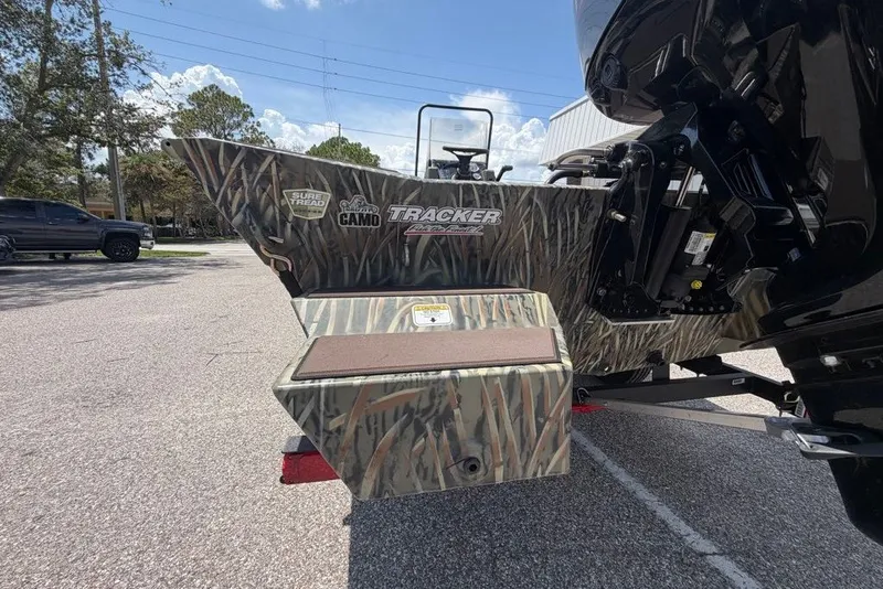 Slide: The Image of 2027 Tracker Grizzly 1860 CC boat with camo design, parked outdoors. - 66