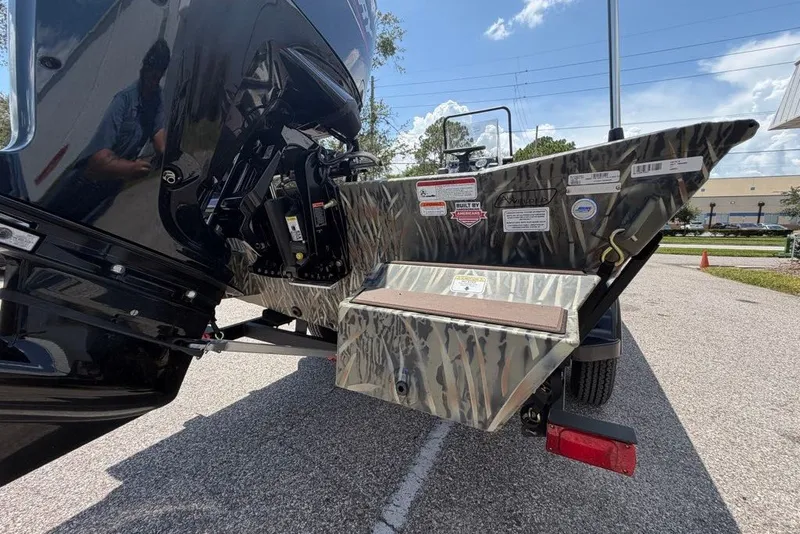 Slide: The Image of 2027 Tracker Grizzly 1860 CC boat rear view with camouflage design and motor details. - 67