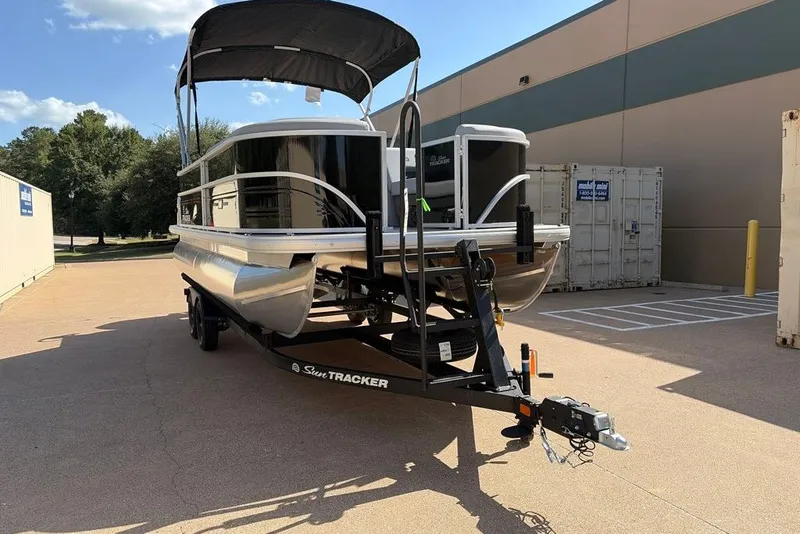 The Image of 2027 Sun Tracker Party Barge 20 DLX pontoon boat on trailer, parked outdoors. - 0