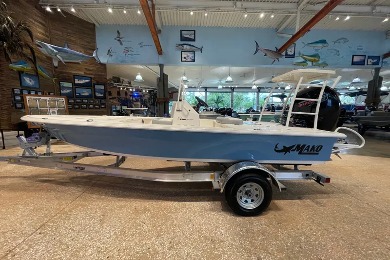 Slide: The Image of 2026 Mako 18 Pro Skiff boat displayed in a showroom with marine decor. - 1