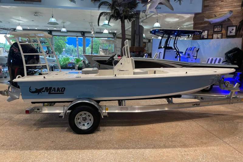 The Image of 2026 Mako 18 Pro Skiff boat displayed indoors on a trailer. - 0