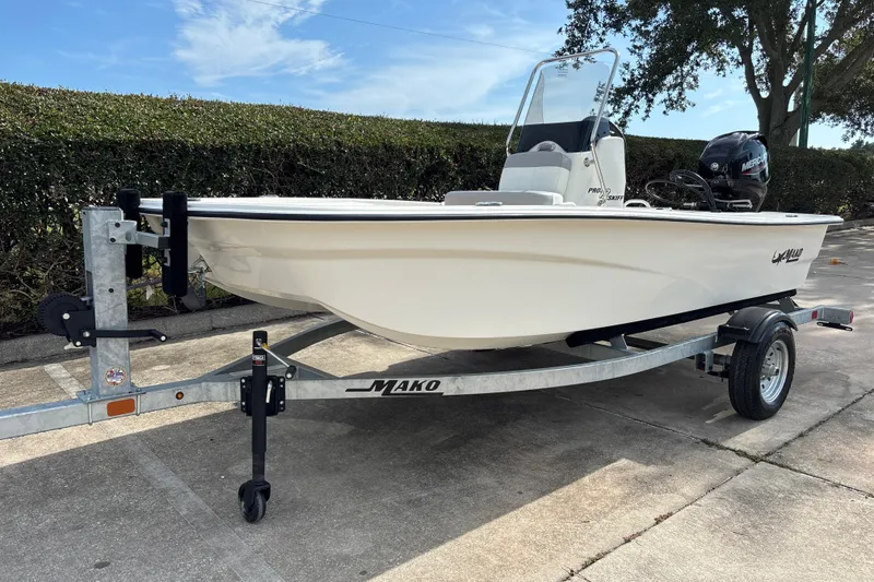 Slide: The Image of 2026 Mako Pro Skiff 13 CC boat on trailer, parked outdoors under clear sky. - 1