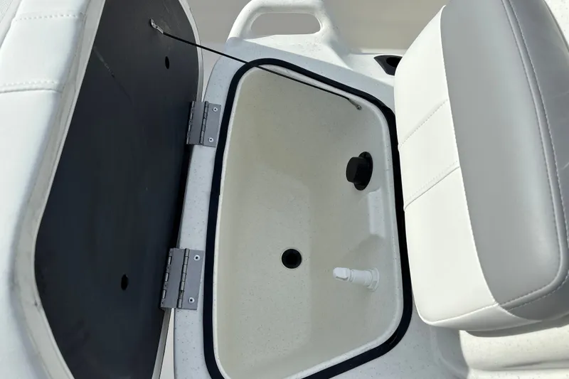 Slide: The Image of Livewell compartment in 2026 Mako Pro Skiff 13 CC boat, featuring white cushioned seating. - 17