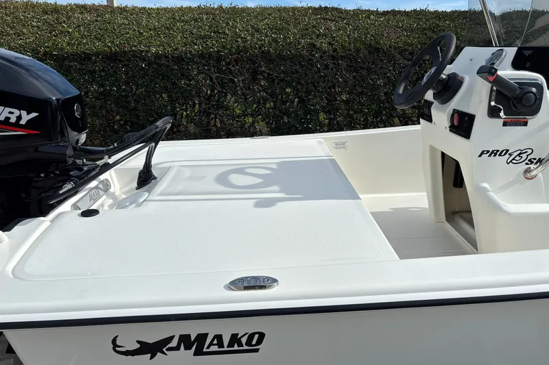 Slide: The Image of 2026 Mako Pro Skiff 13 CC boat with Mercury engine, white interior, and steering console. - 7