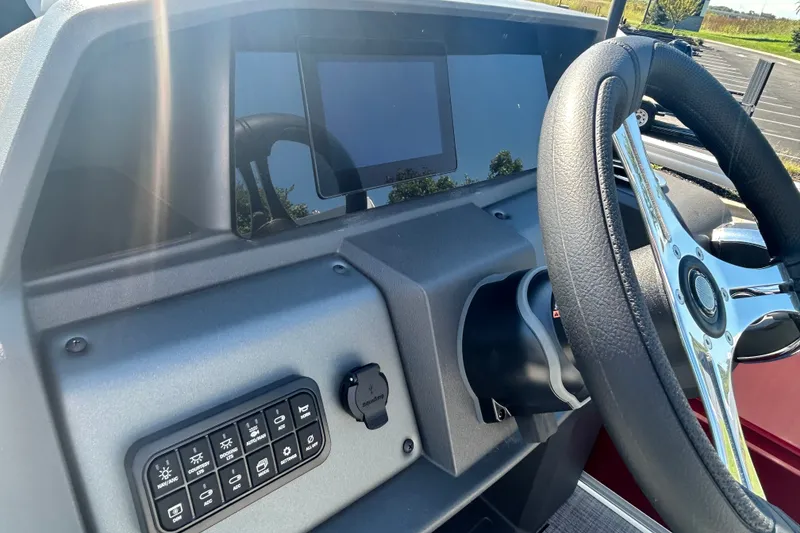 Slide: The Image of Dashboard of 2027 Sun Tracker SportFish 20 DLX with steering wheel and control panel. - 14