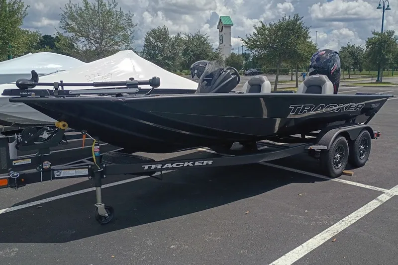 The Image of 2027 Tracker Pro Team 195 boat on trailer in parking lot, under cloudy sky. - 0