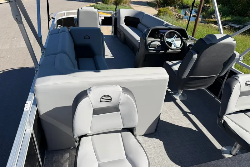 Slide: The Image of 2027 Sun Tracker SportFish 20 DLX pontoon boat interior with gray seating and steering console. - 27