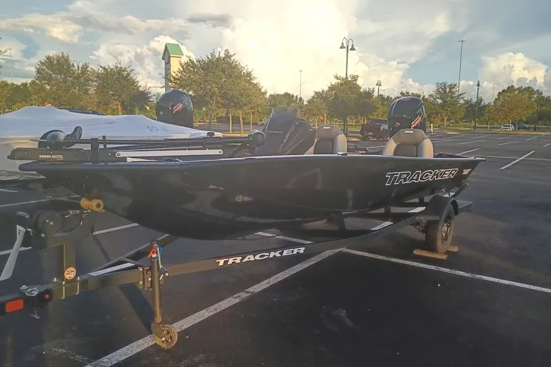 The Image of 2027 Tracker Pro Team 190 boat on trailer in parking lot, sunny day. - 0