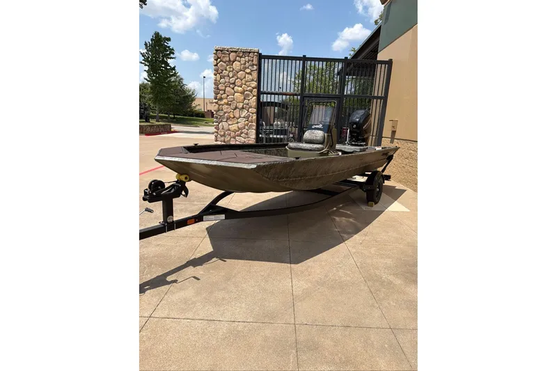 The Image of 2027 Tracker Grizzly 1860 CC boat on trailer, outdoors, sunny day. - 0