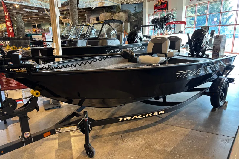 The Image of 2027 Tracker Super Guide V-16 T fishing boat displayed indoors on a trailer. - 0