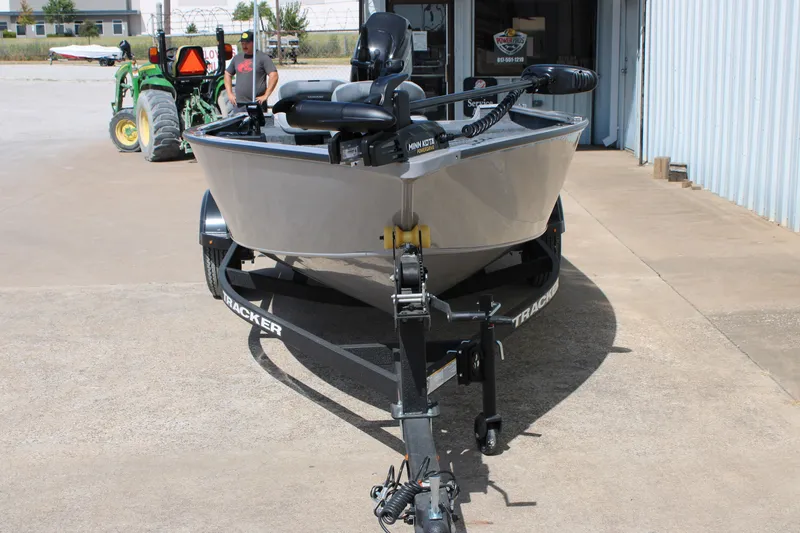 Slide: The Image of 2027 Tracker Super Guide V-16 T boat on trailer, parked outside a building. - 14