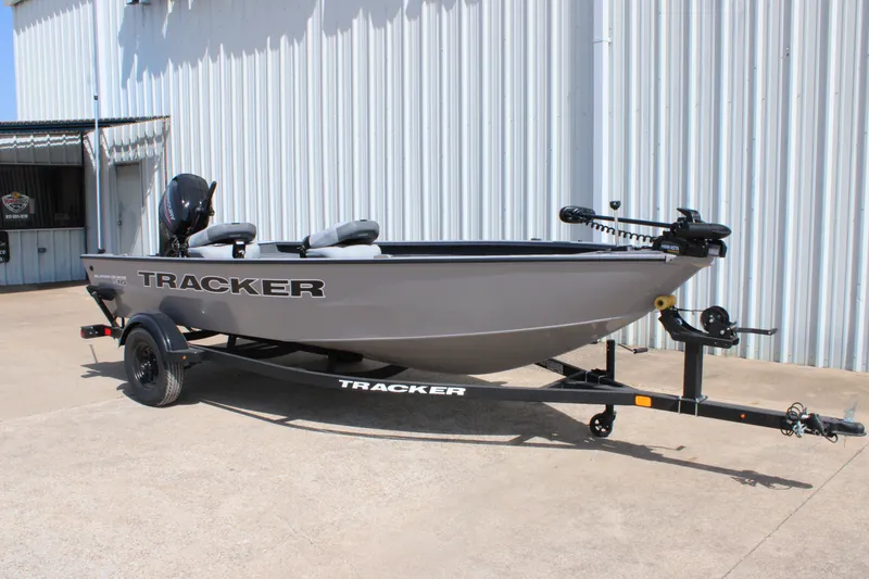 The Image of 2027 Tracker Super Guide V-16 T boat on trailer, parked outside a metal building. - 0